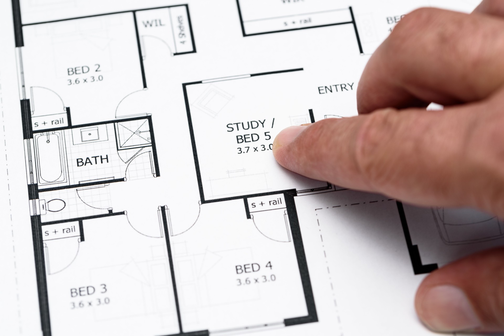 Mans finger pointing to house plans